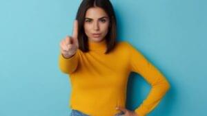 Bela mulher jovem com o dedo indicador erguido como se estivesse dizendo não